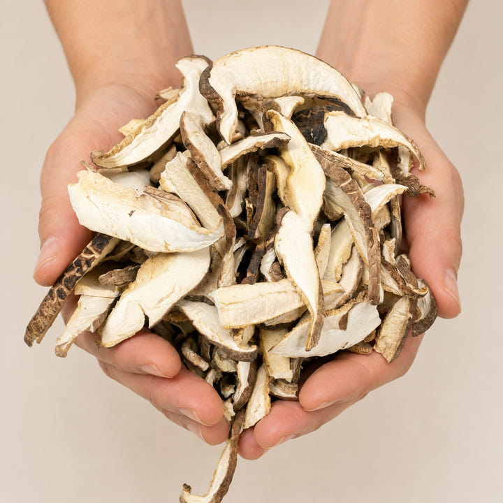 Funghi shiitake secchi a fette mostrati nel palmo delle mani.