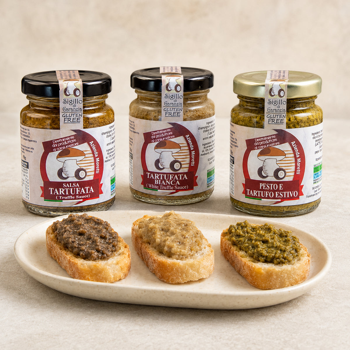 Tris Meraviglia Moretti con salsa tartufata, tartufata bianca e pesto al tartufo, davanti a tre crostini.